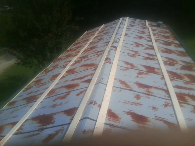 Rusted metal roof panels with new wood purlins before replacement — Storm Damage Roof Repair in Whitehall by Roofing Brothers